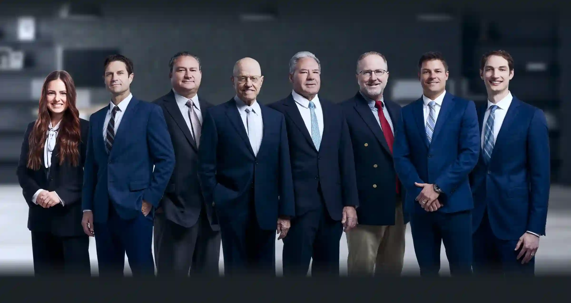 A group of the eight professional lawyers in business attire, representing the Strong Law P.C. legal team.