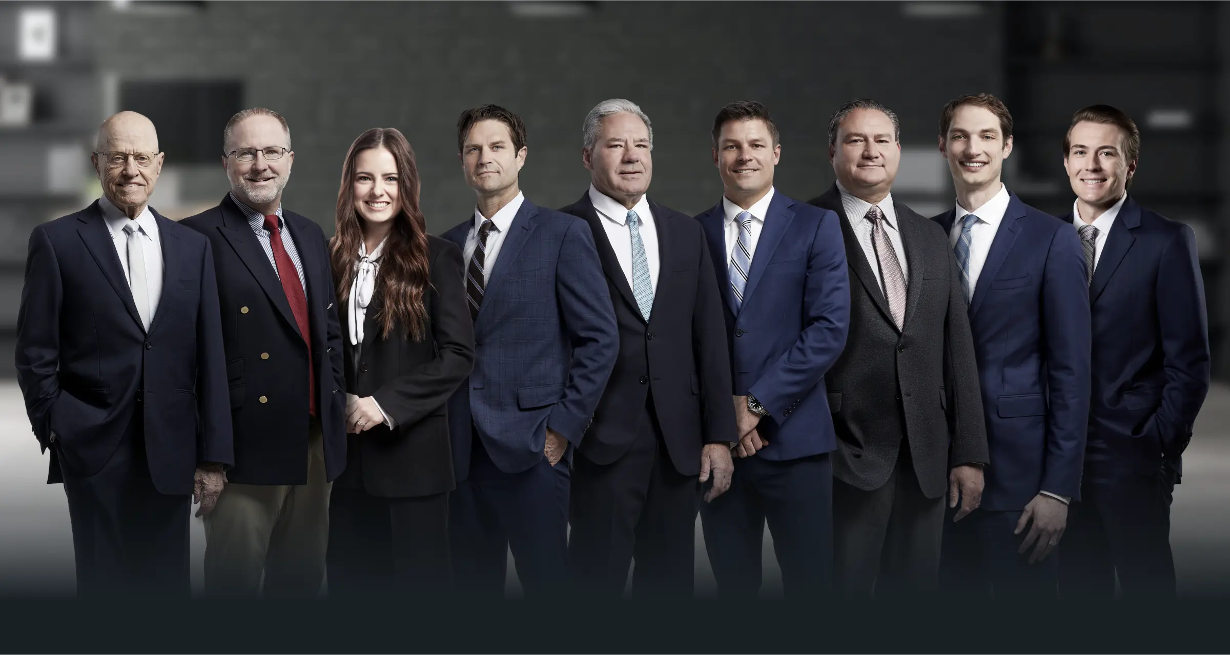 A group of the eight professional lawyers in business attire, representing the Strong Law P.C. legal team.