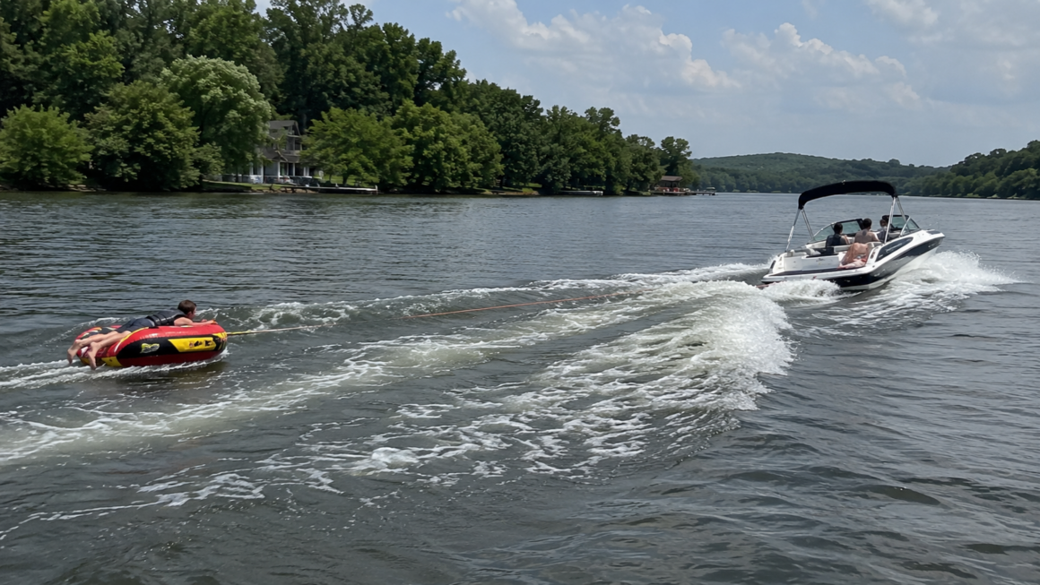 boat pulling a man on a tube on the river