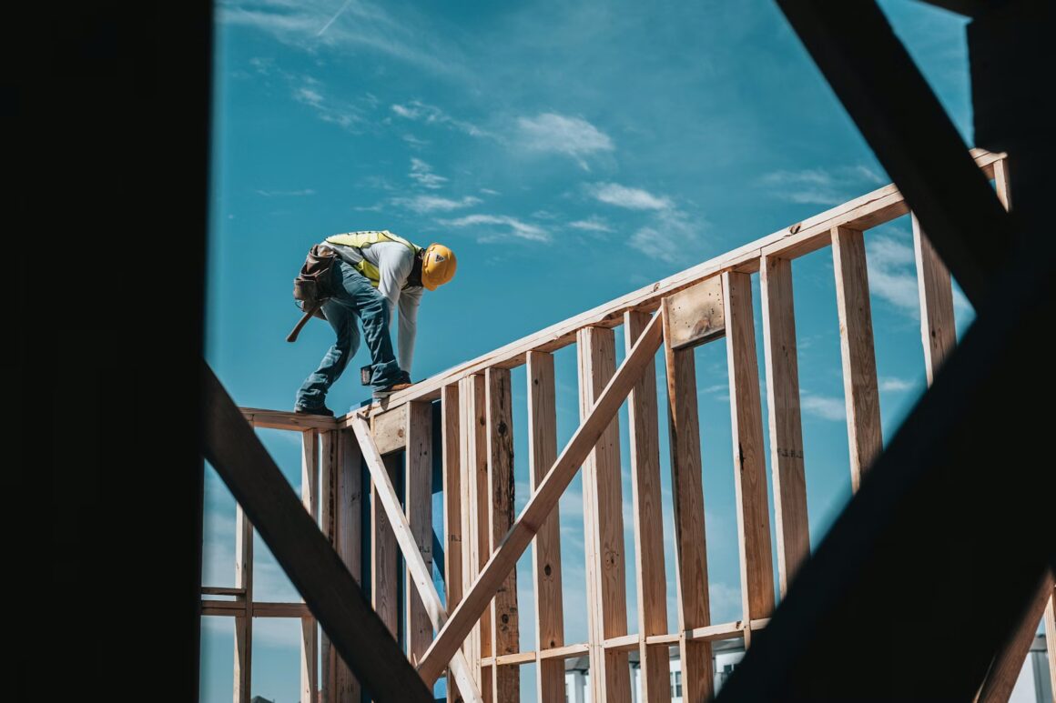 construction worker on top of 2x4 framing